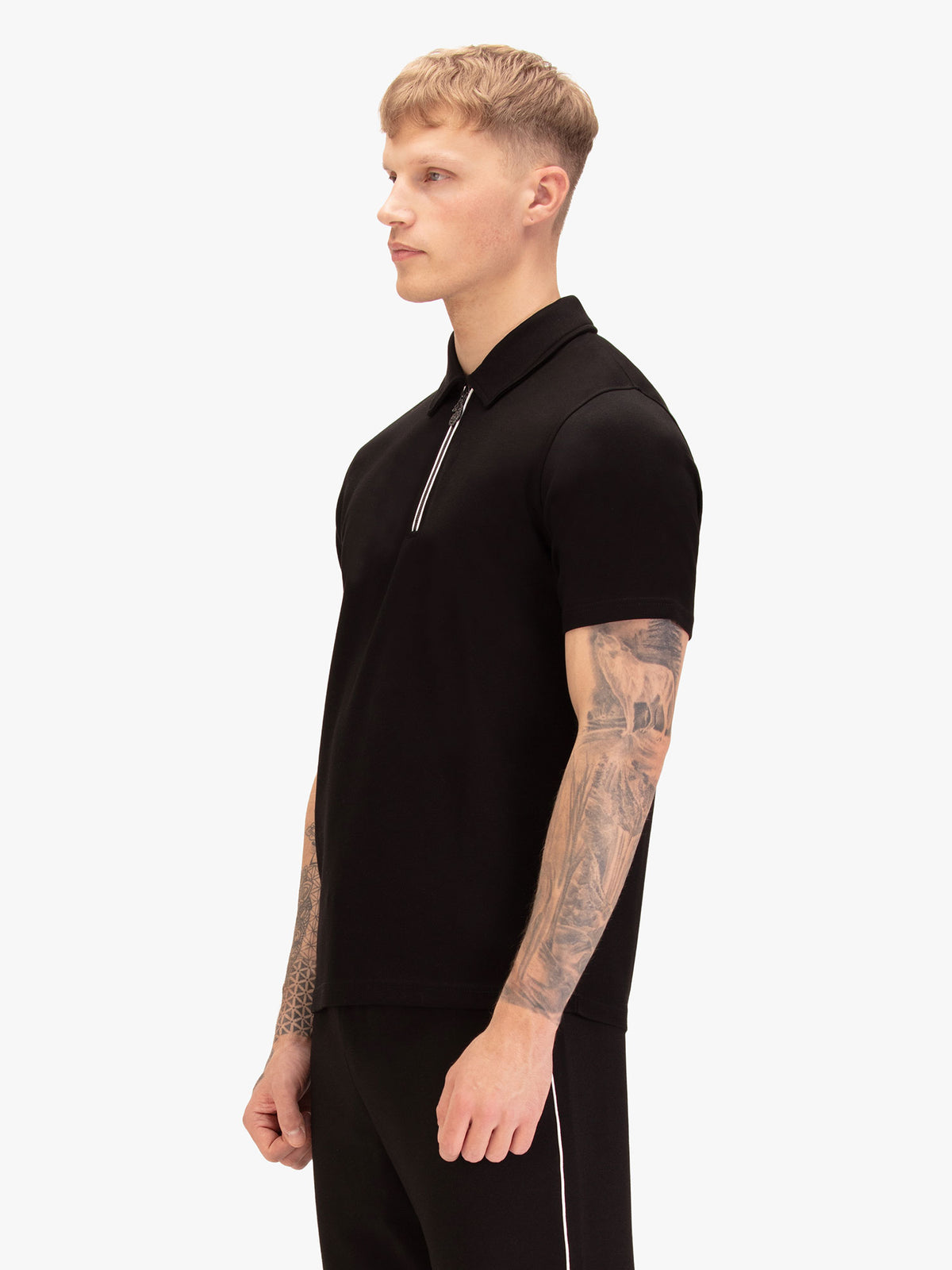 Men's black polo shirt with polo collar, worn by a model, side view