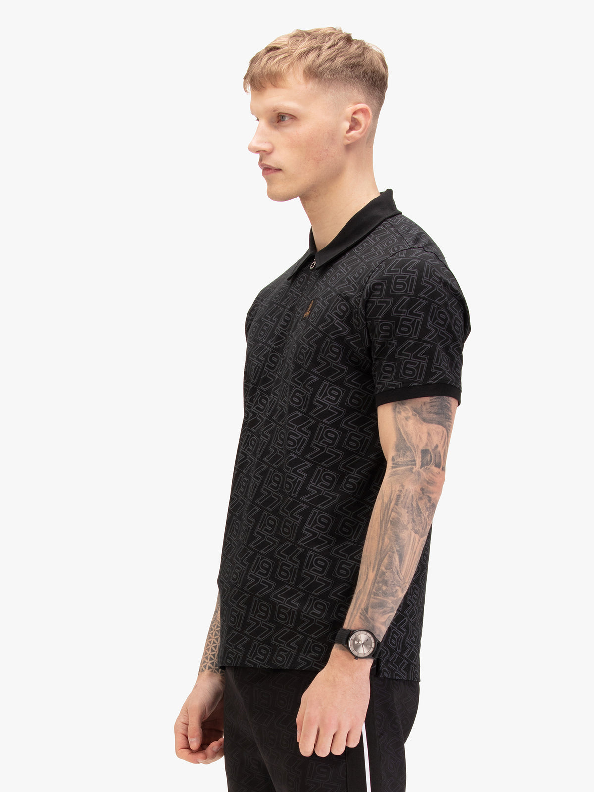 Men's black polo shirt with polo collar, worn by a model, side view