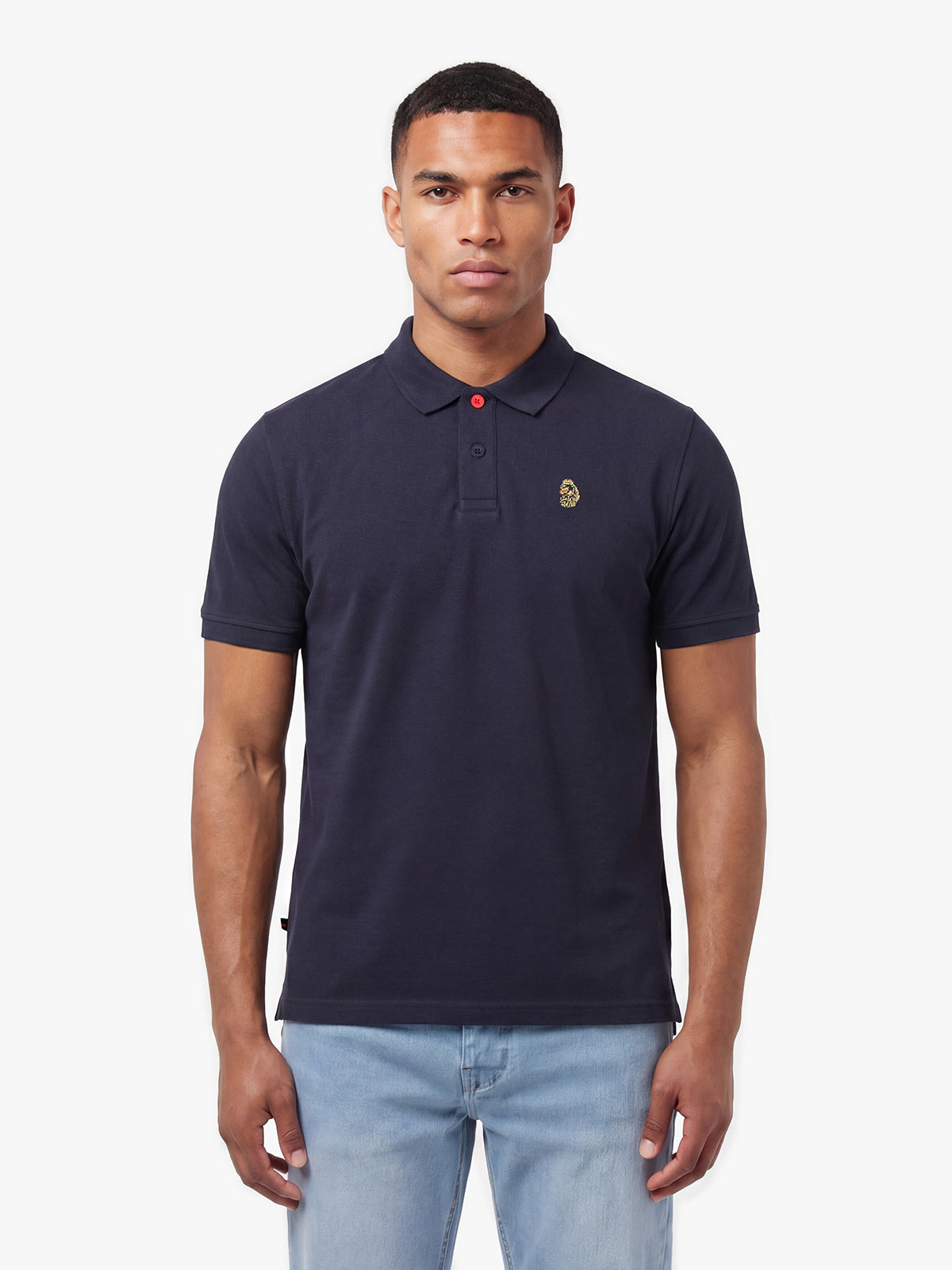 Man wearing navy LUKE 1977 New Mead cotton piqué polo shirt with jeans, front view