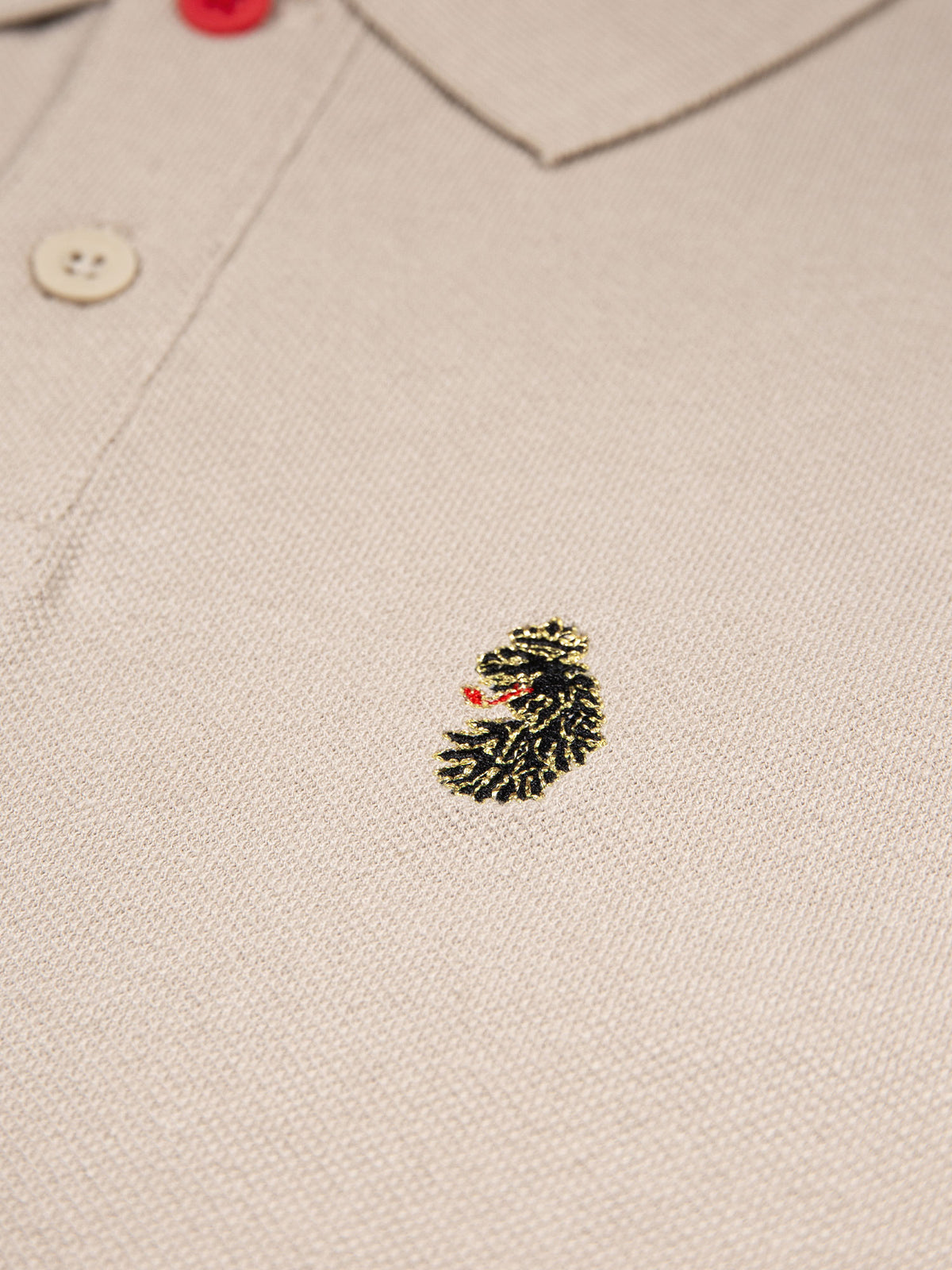 Close-up of LUKE lion embroidery on the chest of stone New Mead cotton piqué polo shirt