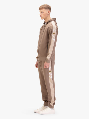 Men's brown tracksuit with zip-up hoodie and matching joggers, worn by model.