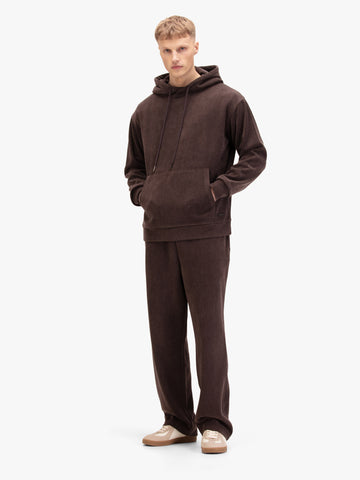Men's relaxed-fit brown tracksuit with pullover hoodie and matching joggers, worn by model.