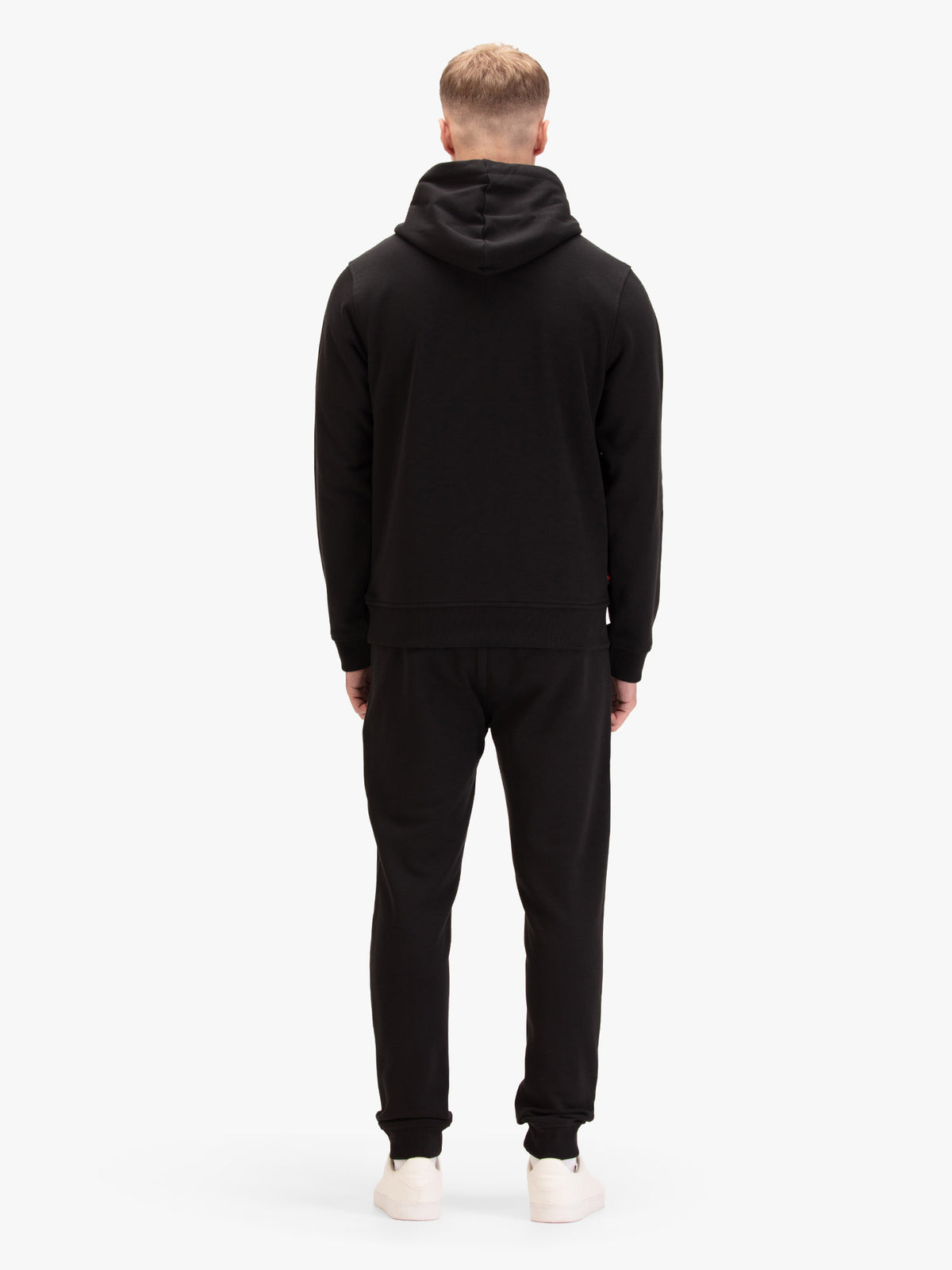 Men's black tracksuit with  hoodie and matching joggers, worn by a model, back view.
