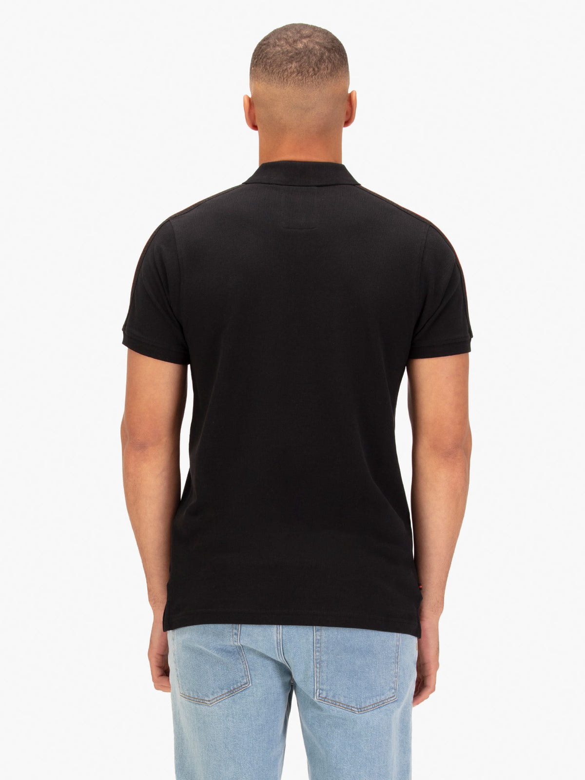 Back view of black LUKE 1977 New Willtape polo shirt worn by model