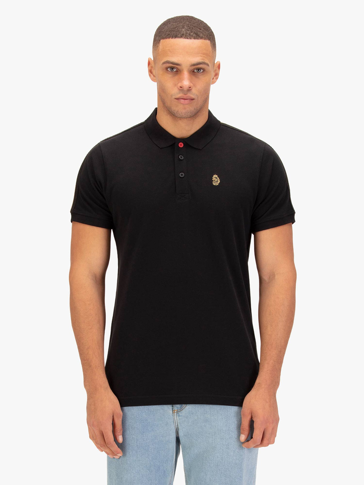 Man wearing black LUKE 1977 New Willtape pique polo shirt with jeans, front view