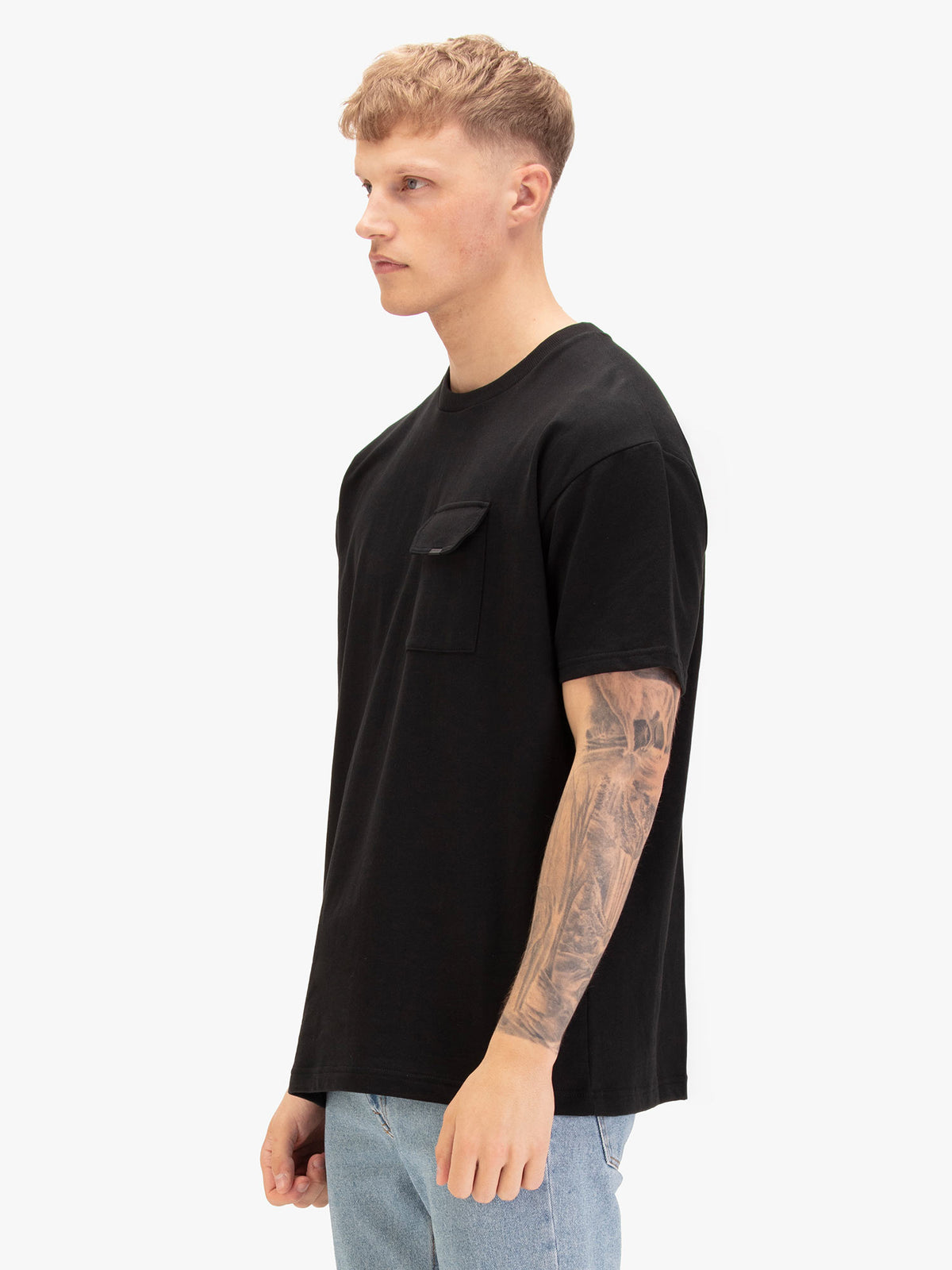 Men's relaxed-fit black t-shirt with crew neck and short sleeves, worn by a model, side view