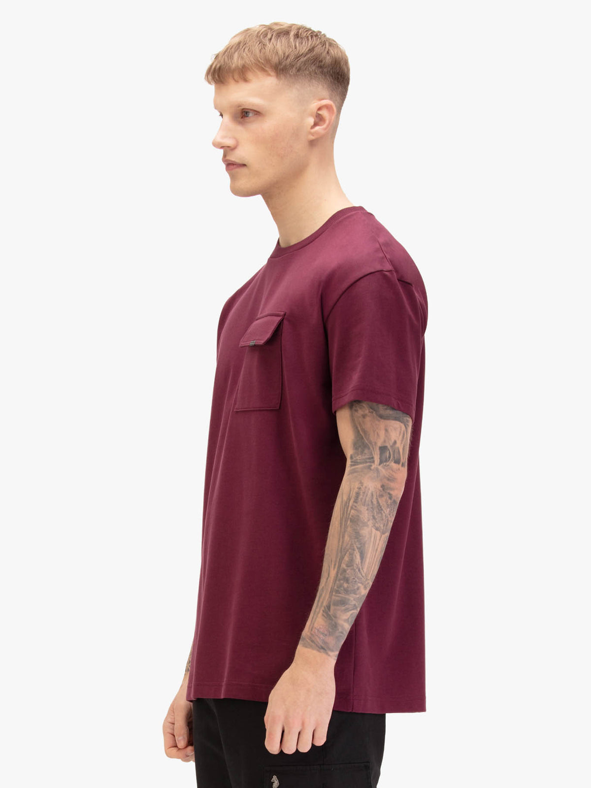 Men's relaxed-fit red t-shirt with crew neck and short sleeves, worn by a model, side view