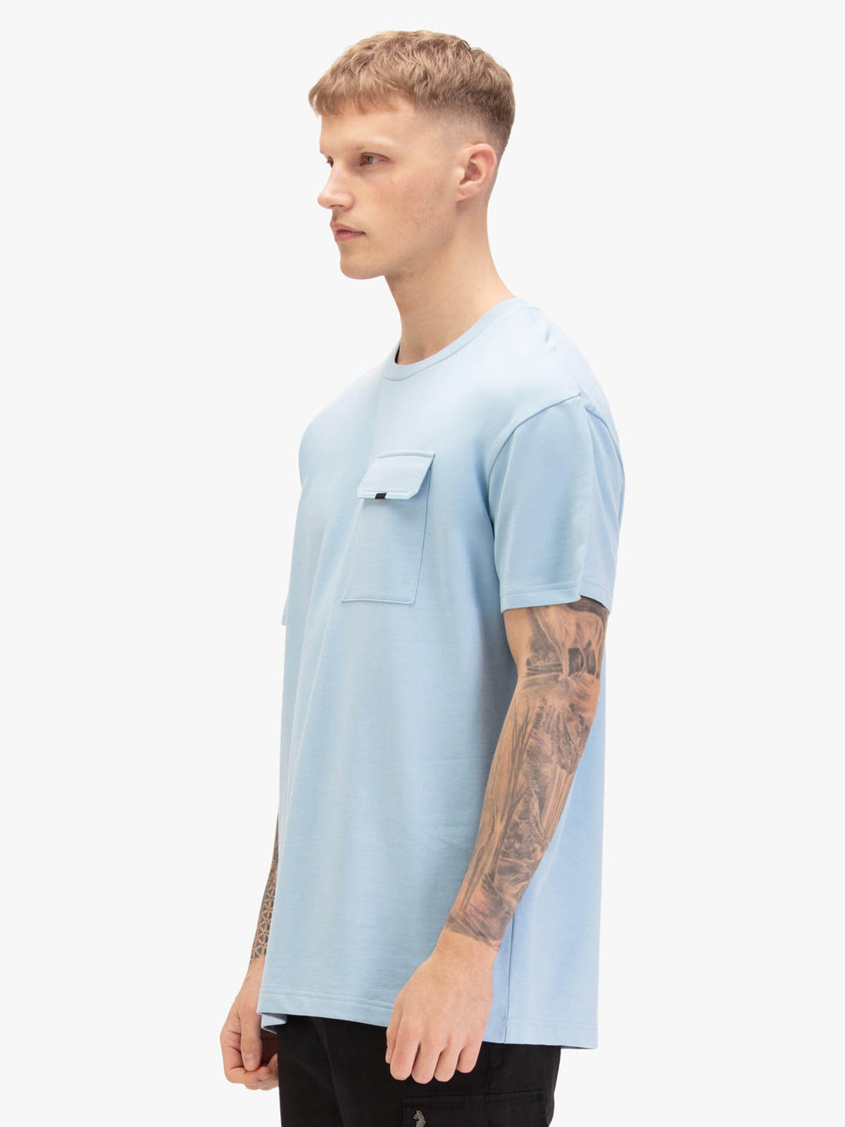 Men's relaxed-fit blue t-shirt with crew neck and short sleeves, worn by a model, side view