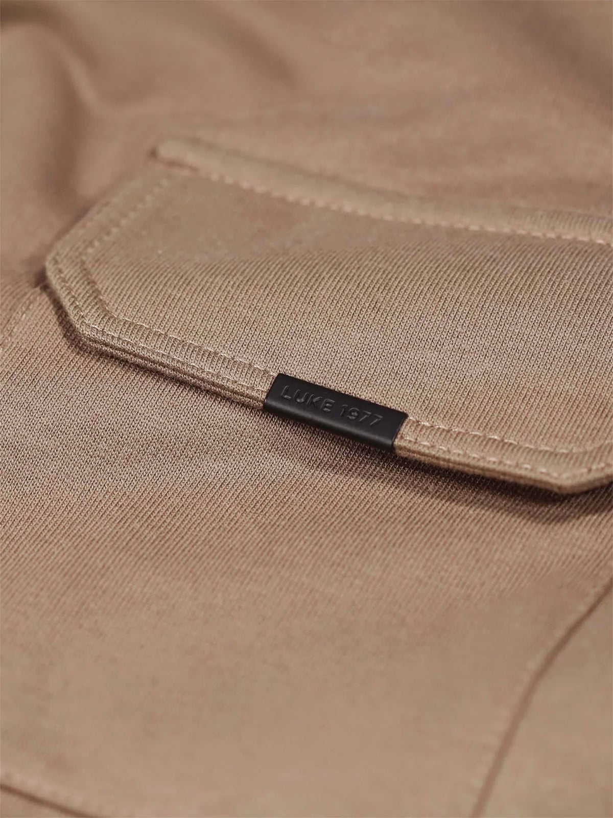 Close-up of chest pocket flap with LUKE 1977 text branded metal clip on Hard Nut brown Dragger t-shirt
