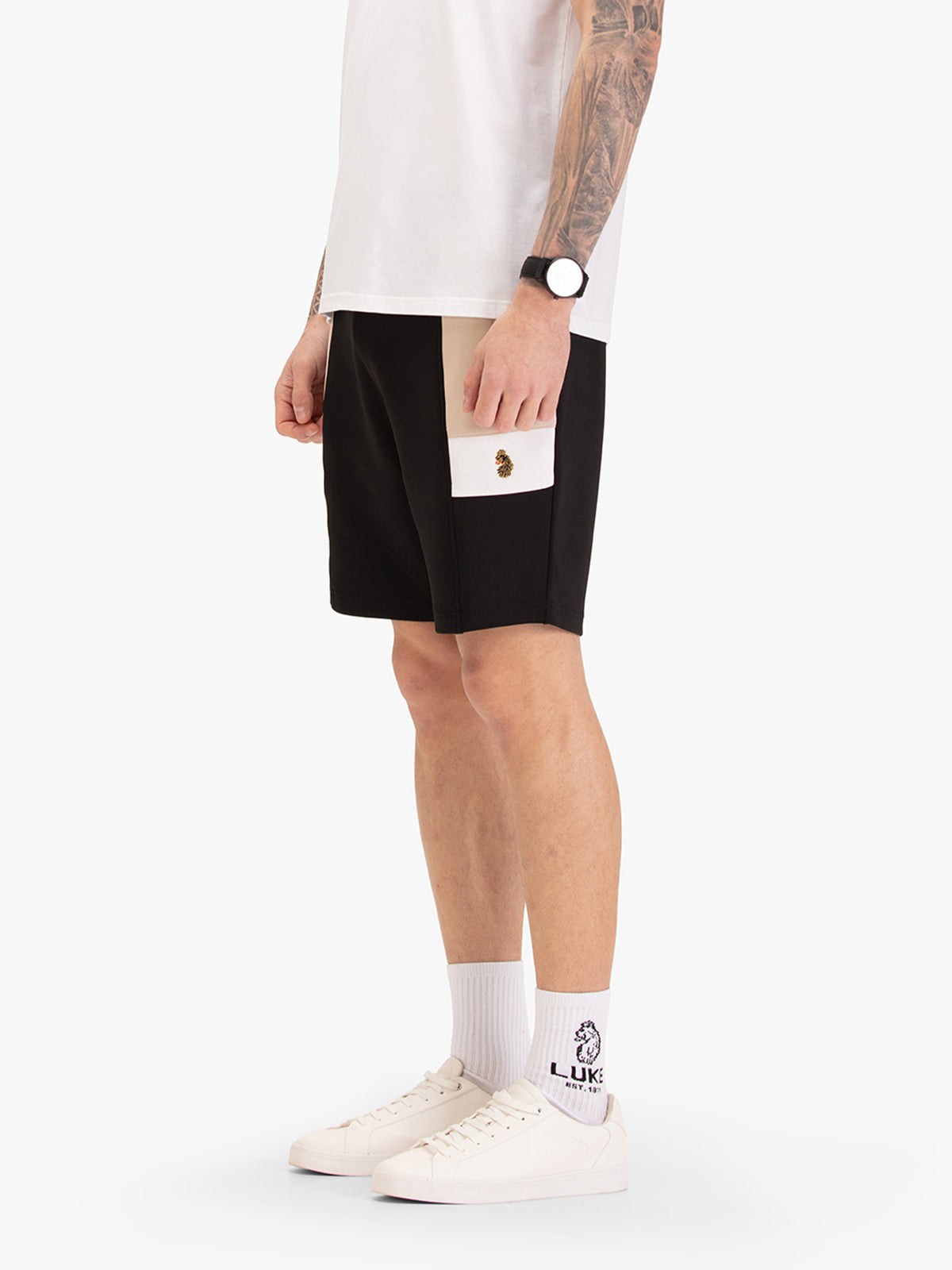Men's black shorts with drawstring waistband, worn by a model, side view