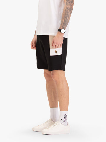 Men's black shorts with drawstring waistband, worn by a model, side view