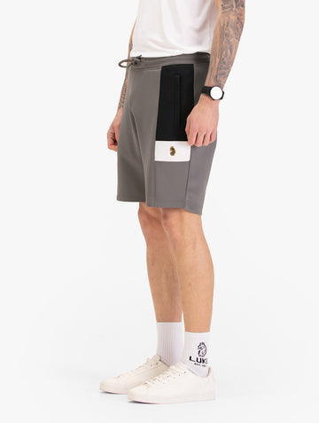 Men's grey shorts with drawstring waistband, worn by a model, side view