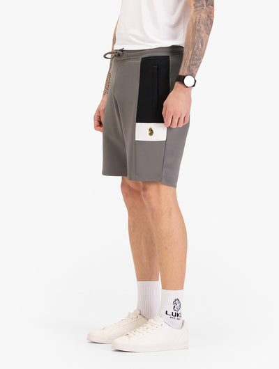 Men's grey shorts with drawstring waistband, worn by a model, side view