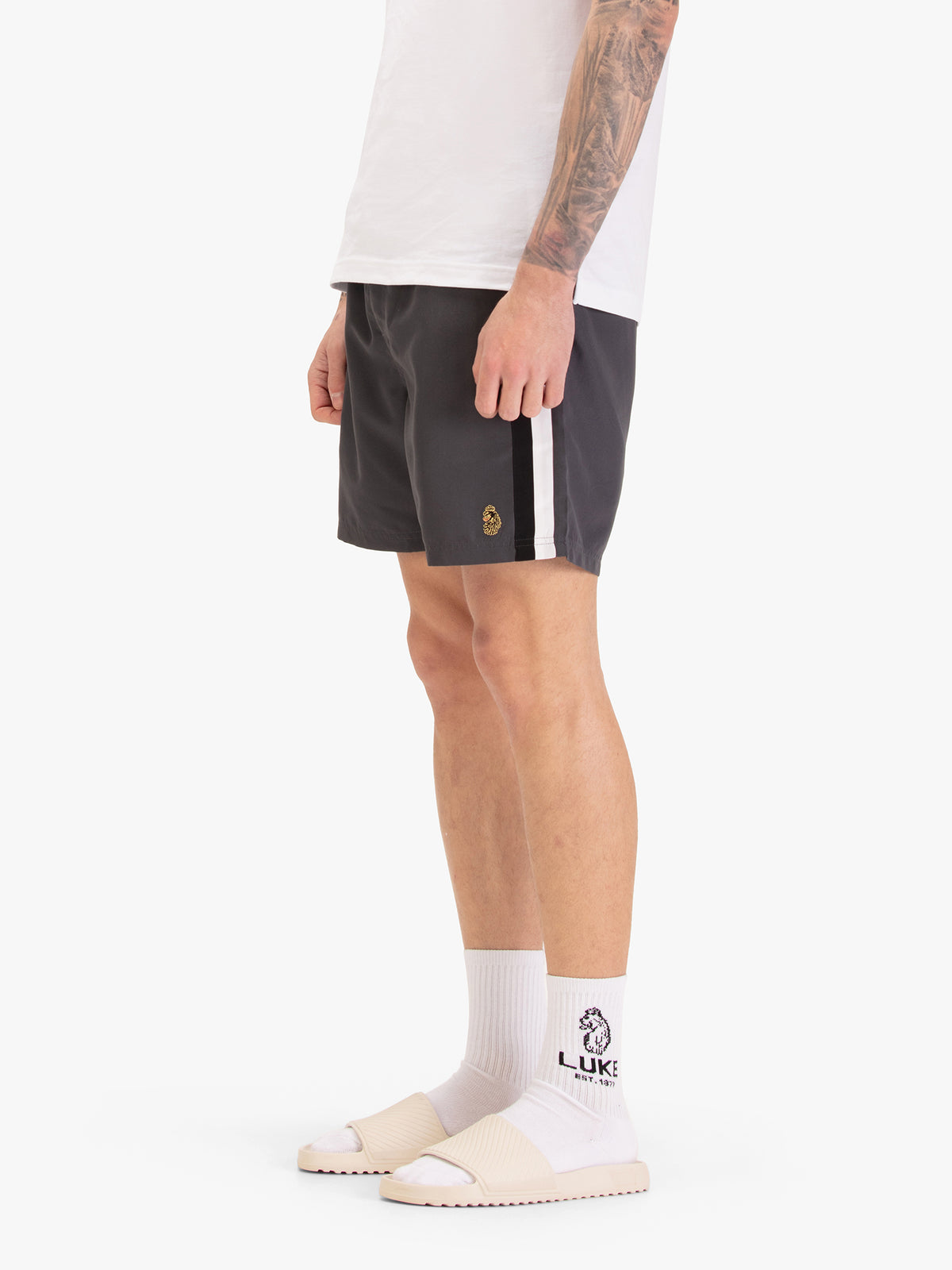 Men's grey swim shorts with drawstring waistband, worn by a model, worn by a model, side view
