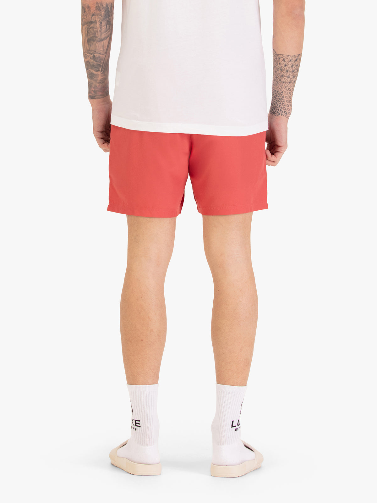 Men's red swim shorts with drawstring waistband, worn by a model, back view