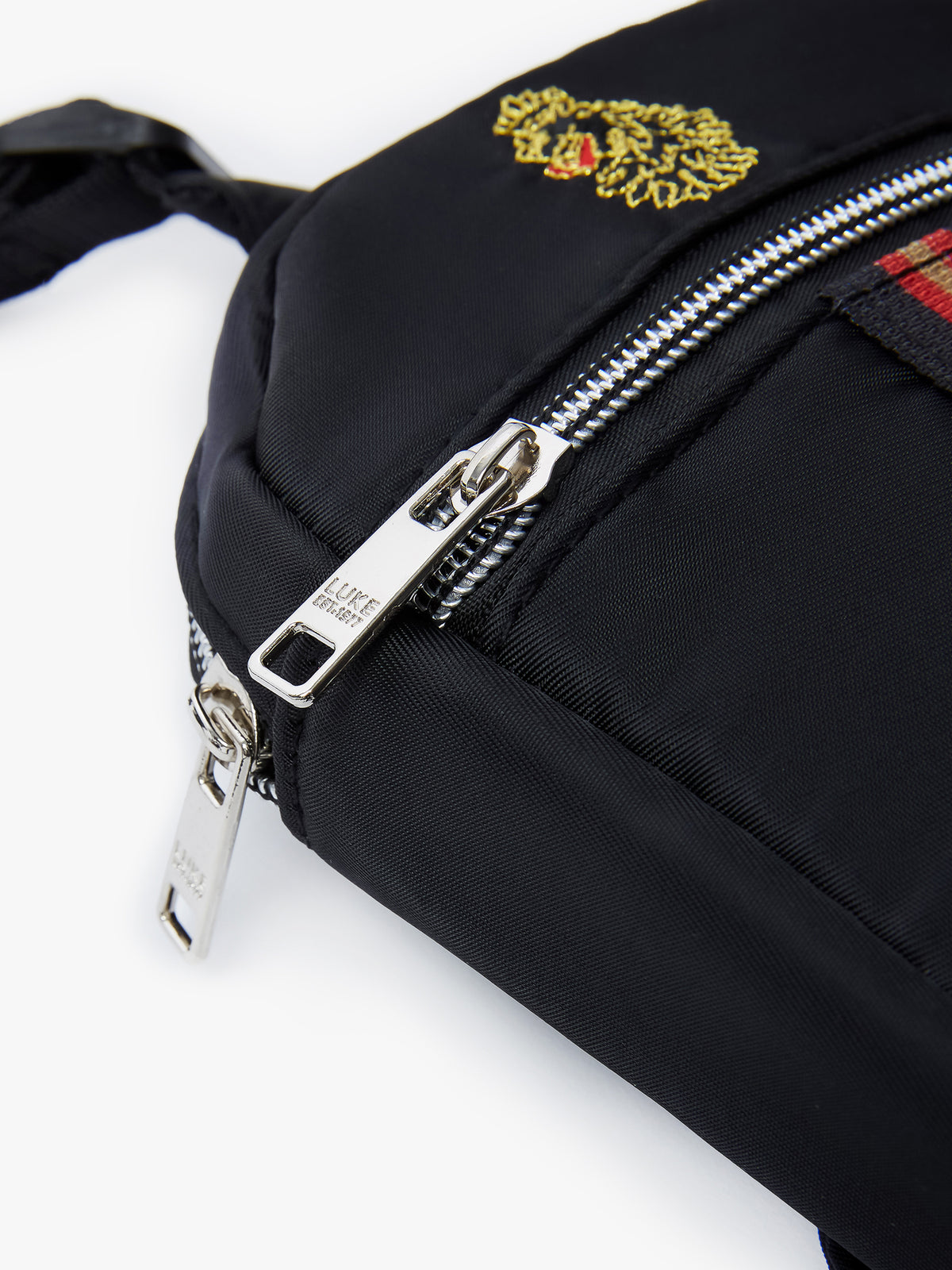 Close-up of chrome LUKE 1977 zip pullers on black Euston cross body bag