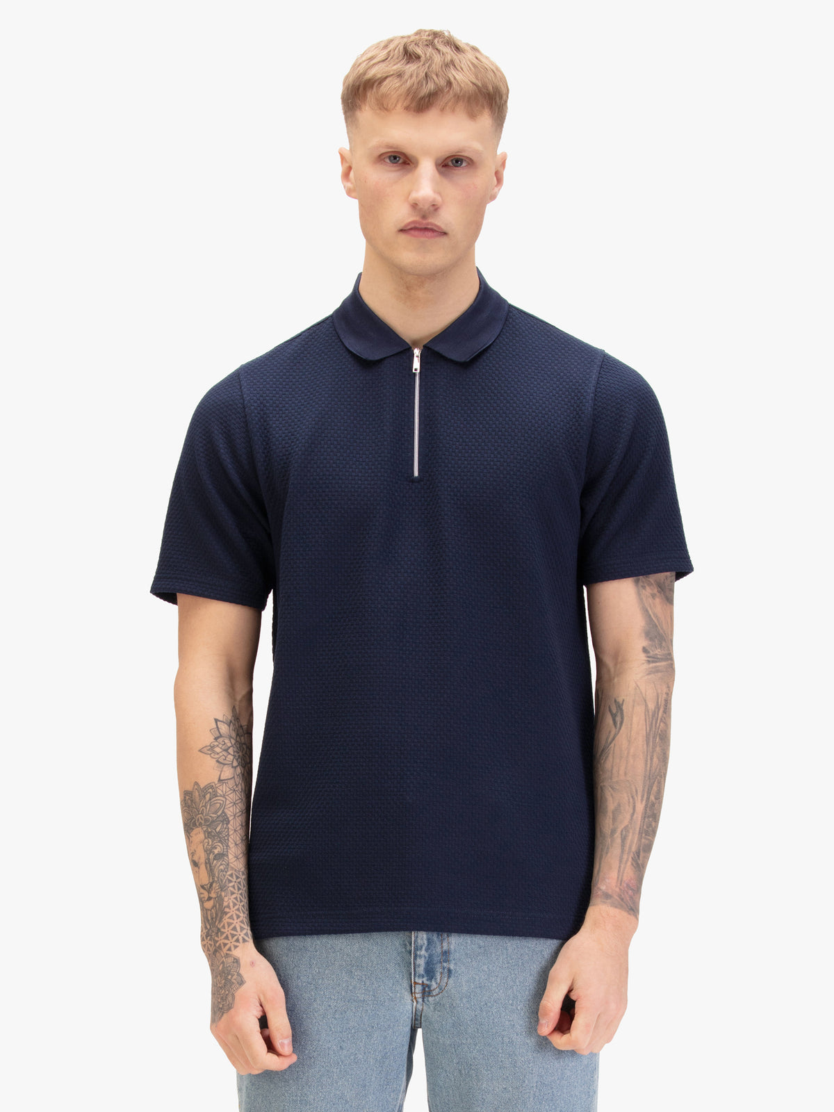 Men's navy polo shirt with zip collar, worn by model, front view