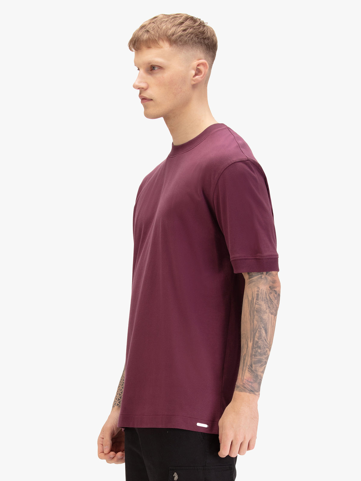 Men's relaxed-fit purple t-shirt with crew neck and short sleeves, worn by a model, side view