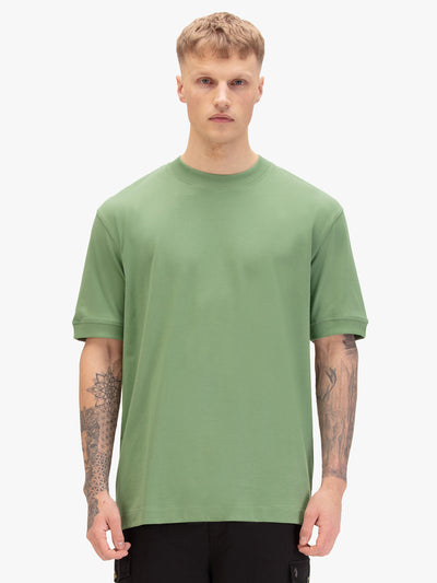 Men's relaxed-fit green t-shirt with crew neck and short sleeves, worn by a model, front view