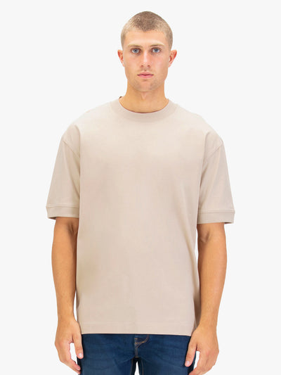 Men's relaxed-fit beige t-shirt with crew neck and short sleeves, worn by a model, front view