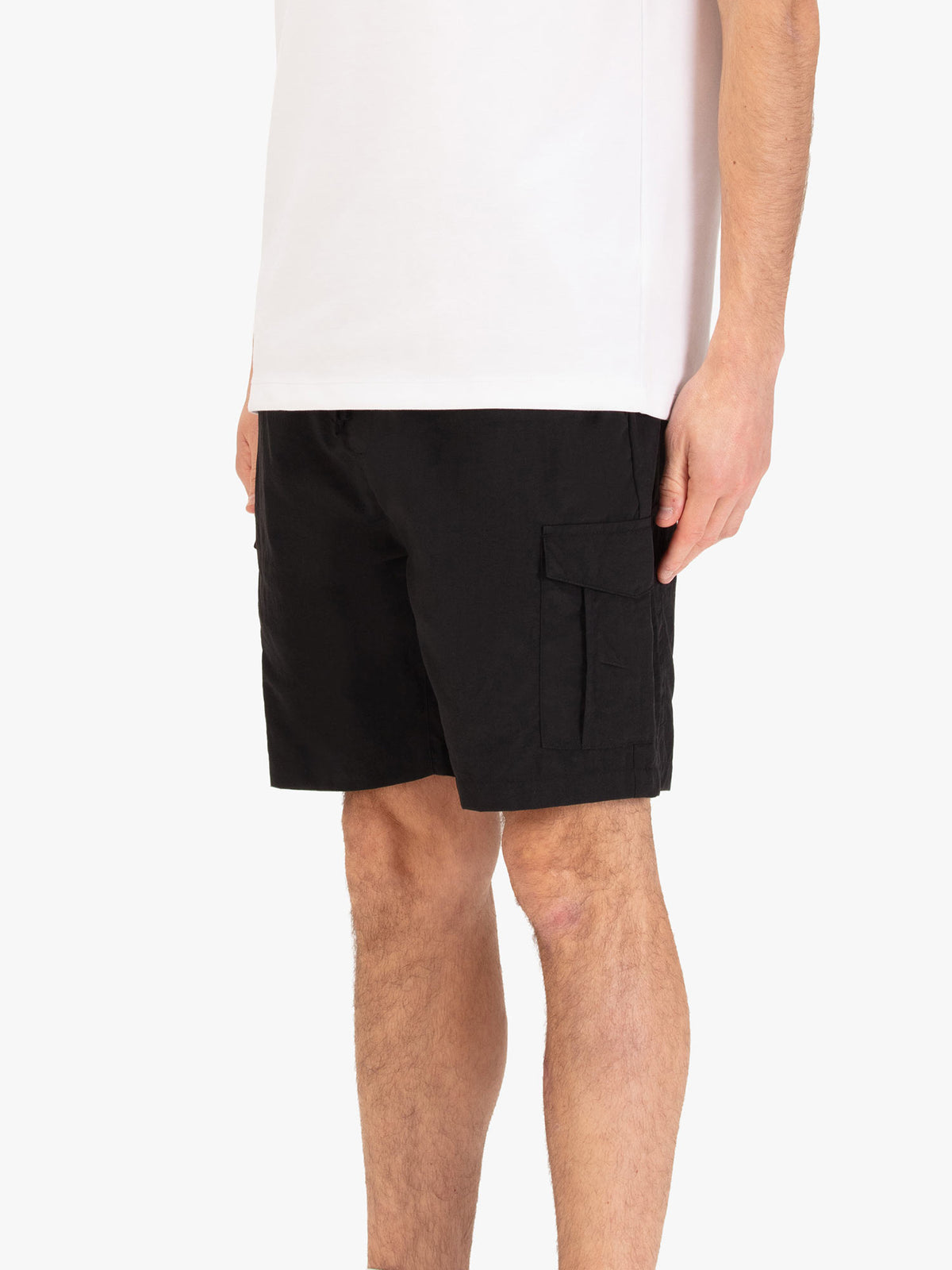 Men's black shorts with elasticated waistband, worn by a model, side view