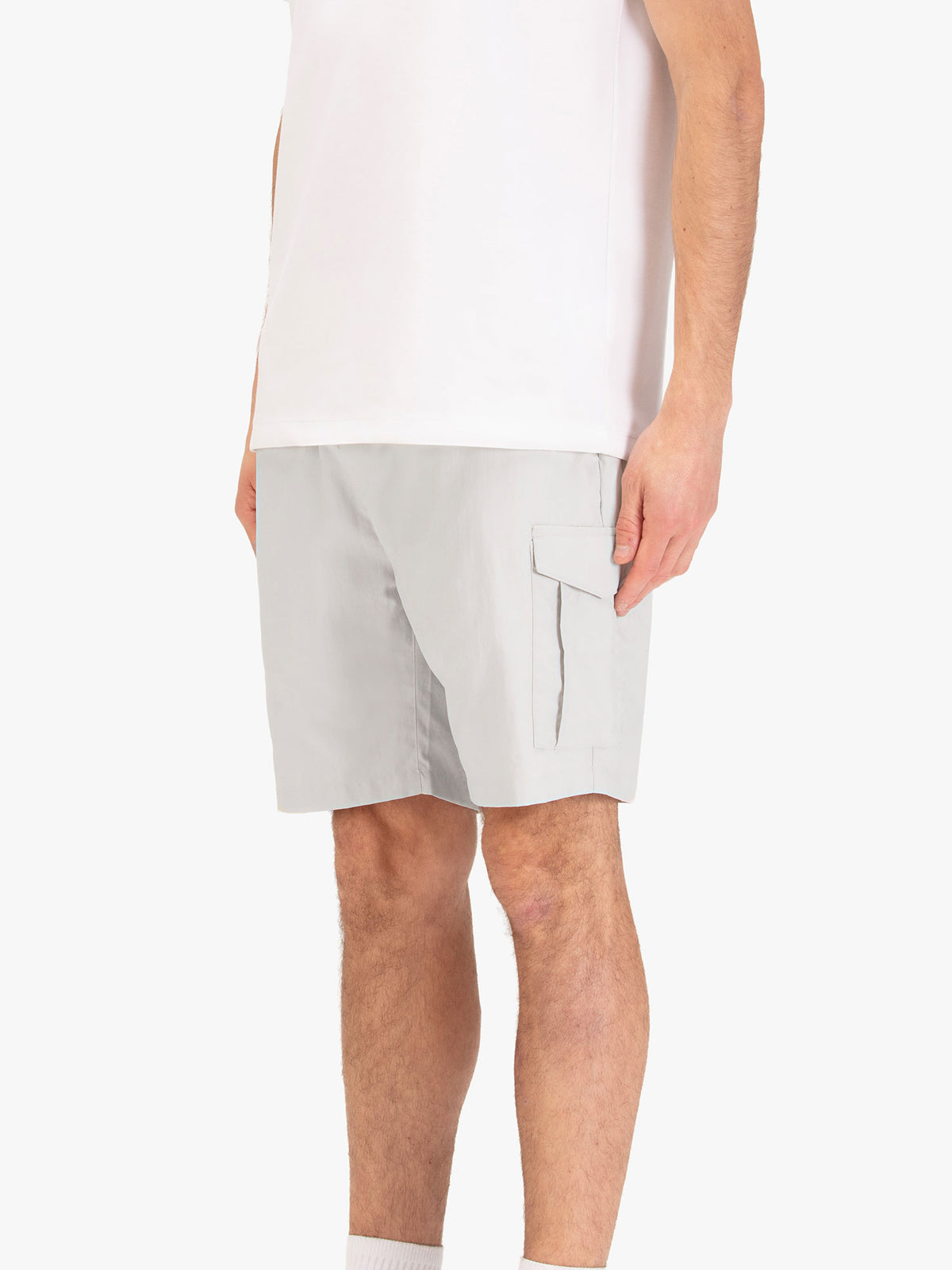 Men's grey shorts with elasticated waistband, worn by a model, side view