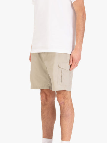 Men's beige shorts with elasticated waistband, worn by a model, side view