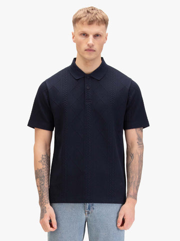 Men's navy polo shirt with polo collar, worn by a model, front view