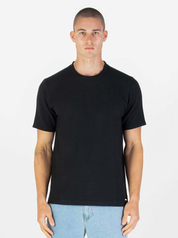 Men's black t-shirt with crew neck and short sleeves worn by a model - front view.