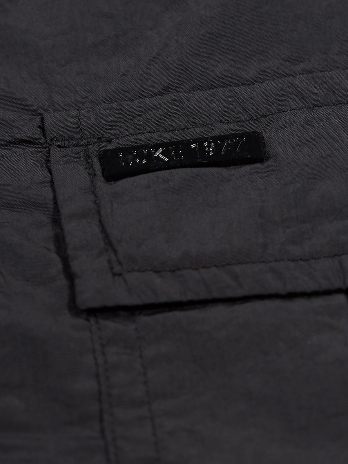 Men's black jacket with button-up front and chest pocket.
