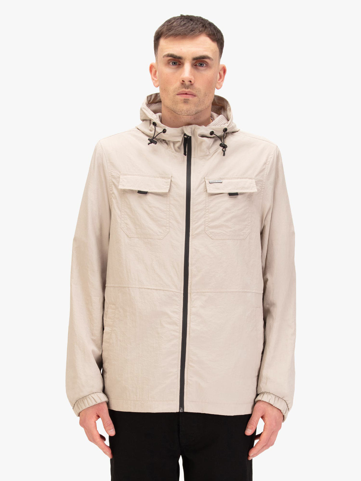 Men's beige jacket with chest pocket, worn by a model, front view