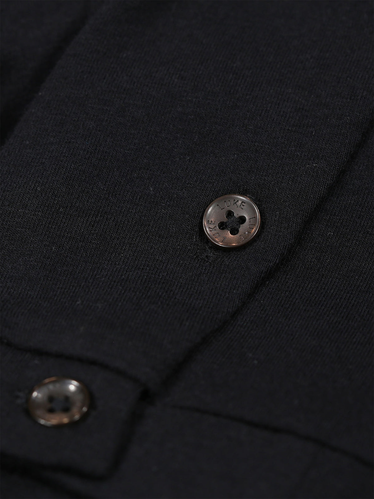 Close-up of button cuff detail on the sleeve of black Shanghai Modal t-shirt