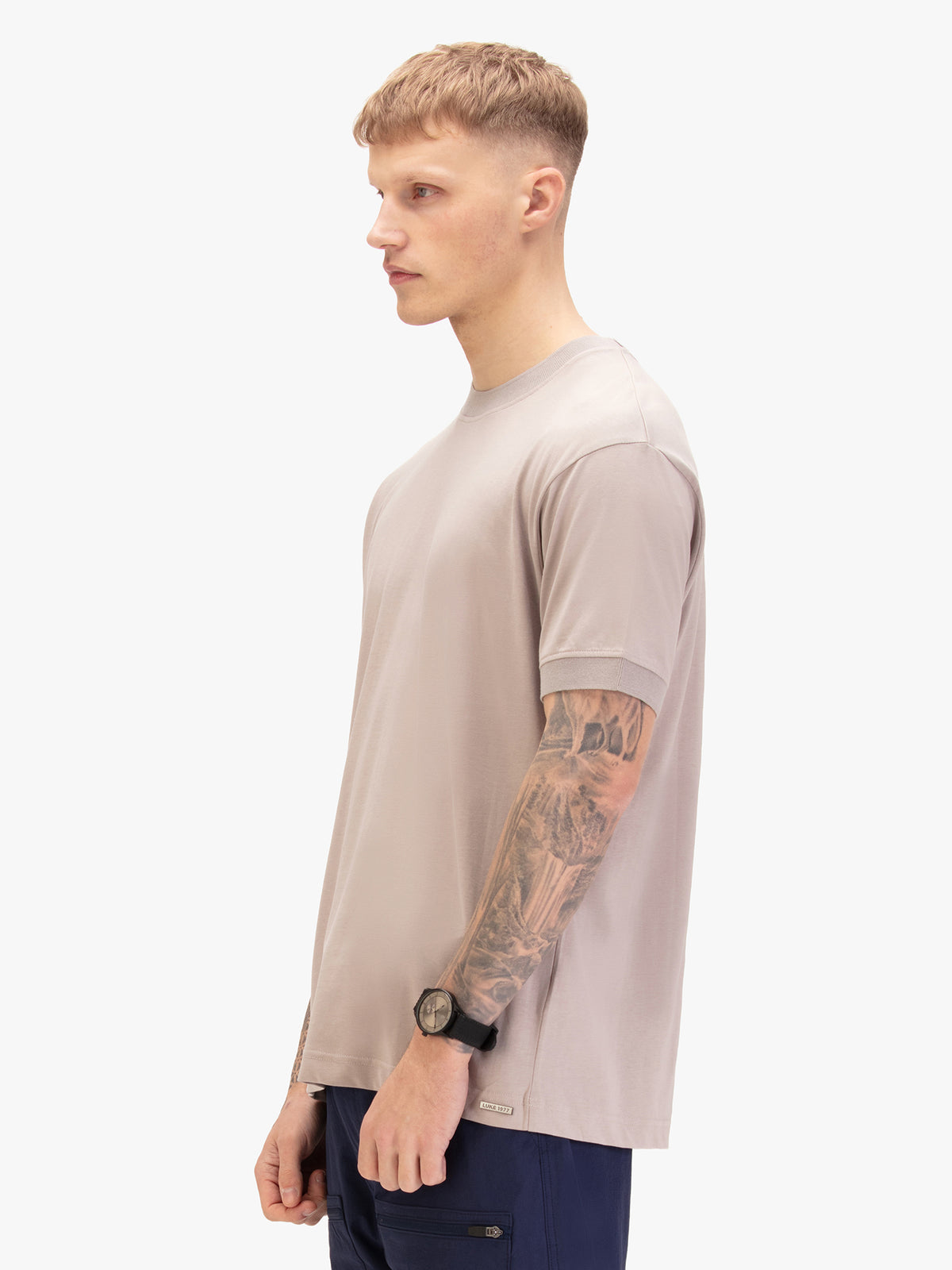 Men's grey t-shirt with crew neck and short sleeves worn by a model - side view.