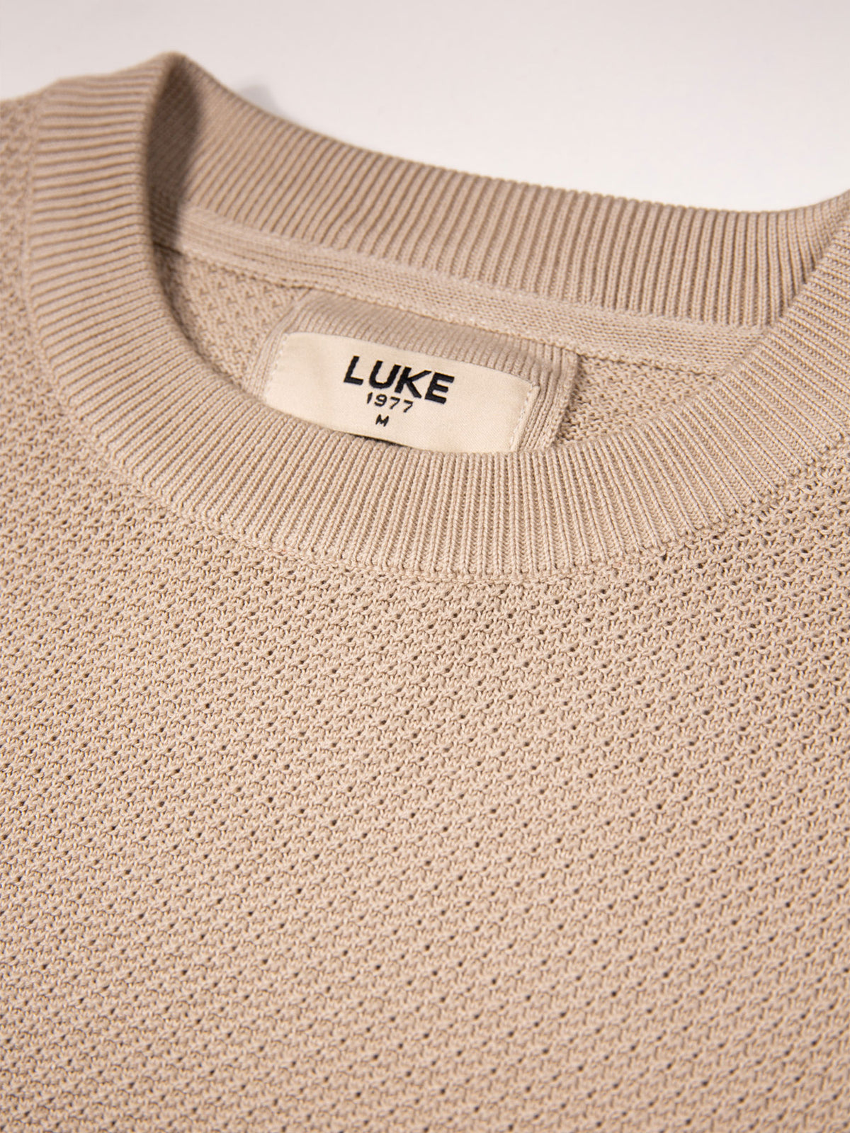 Men's beige t-shirt with crew neck and short sleeves worn by a model - back view.