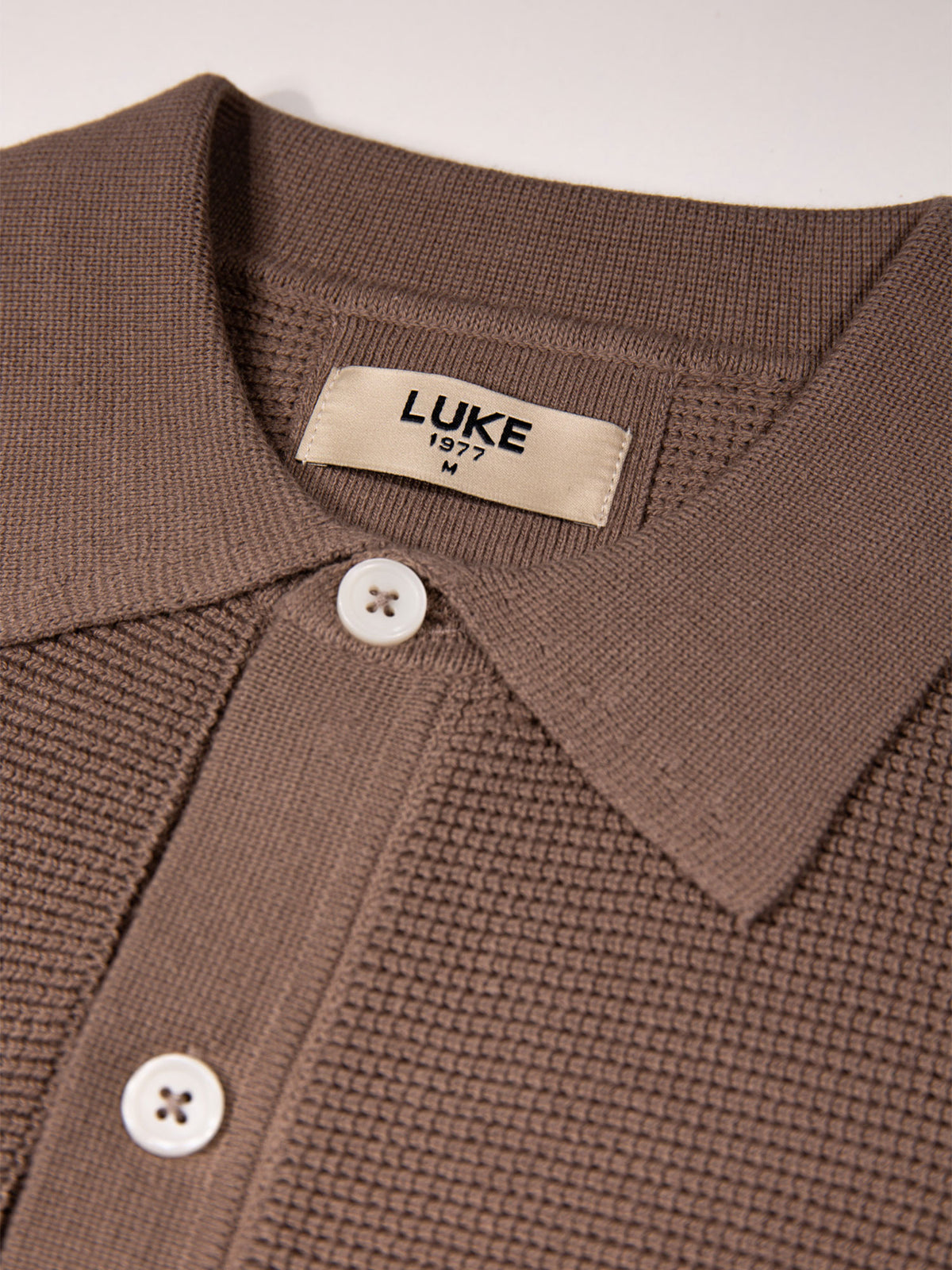 Men's brown knitted polo with polo collar.
