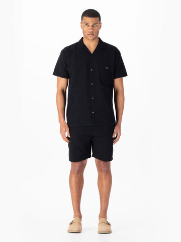 Men's black short set with short-sleeve shirt and matching shorts.