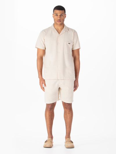 Men's beige short set with short-sleeve shirt and matching shorts.