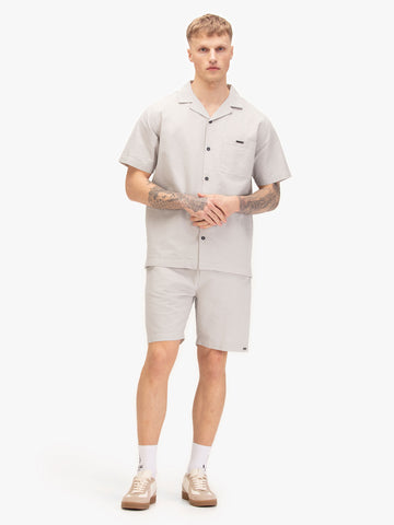 Men's grey short set with short-sleeve button-up shirt and matching shorts, worn by a model.