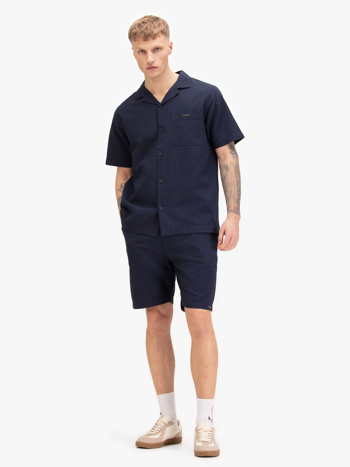 Men's navy short set with short-sleeve button-up shirt and matching shorts, worn by a model.
