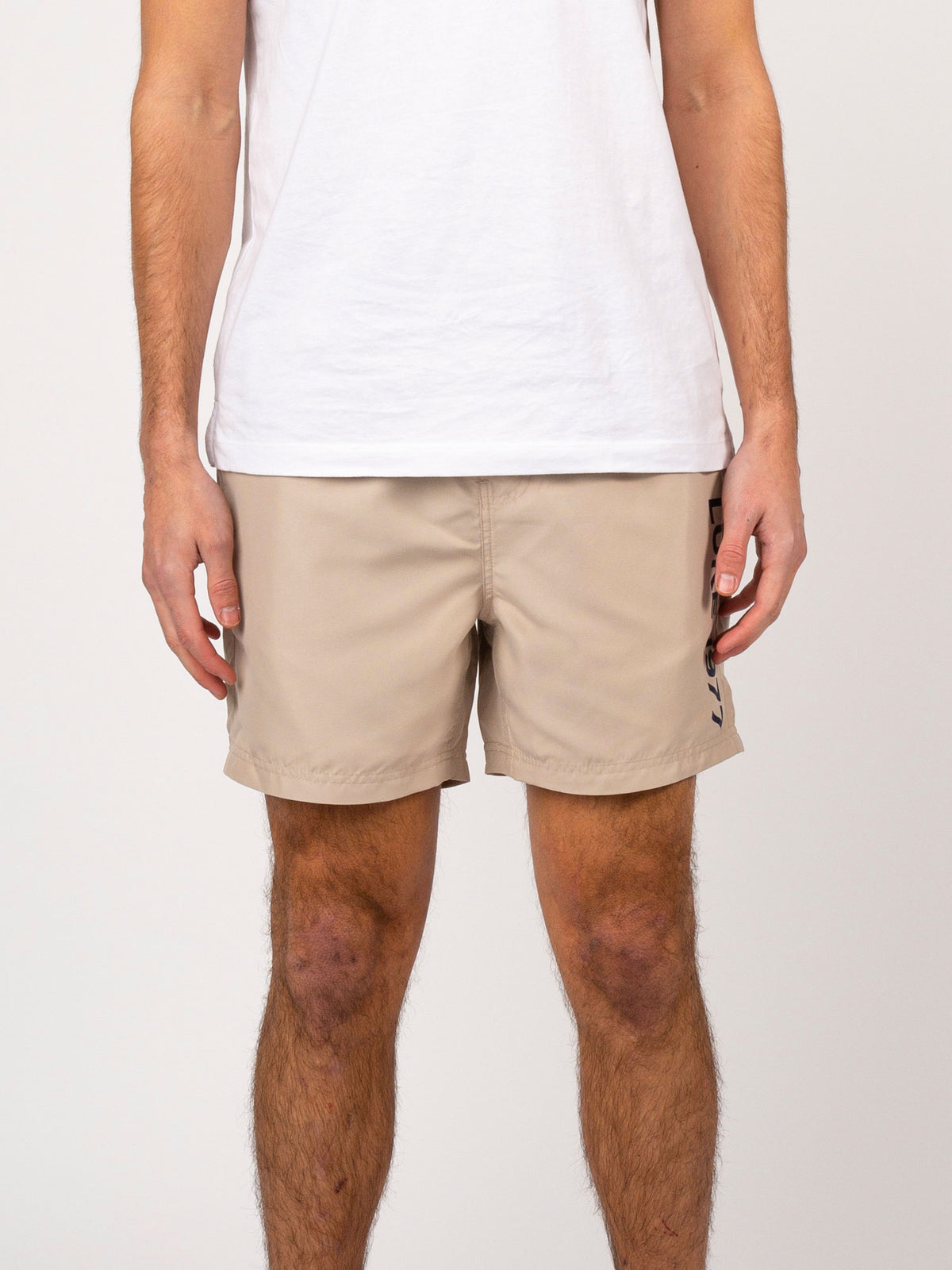 Men's beige swim shorts with drawstring waistband.