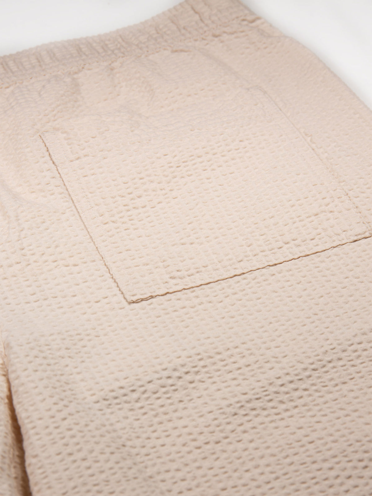 Men's beige shorts with drawstring waistband.