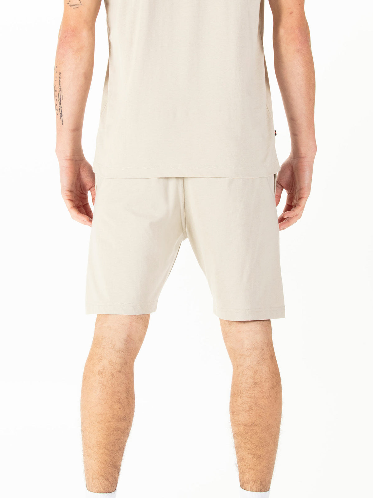Men's beige shorts with drawstring waistband, worn by a model, back view