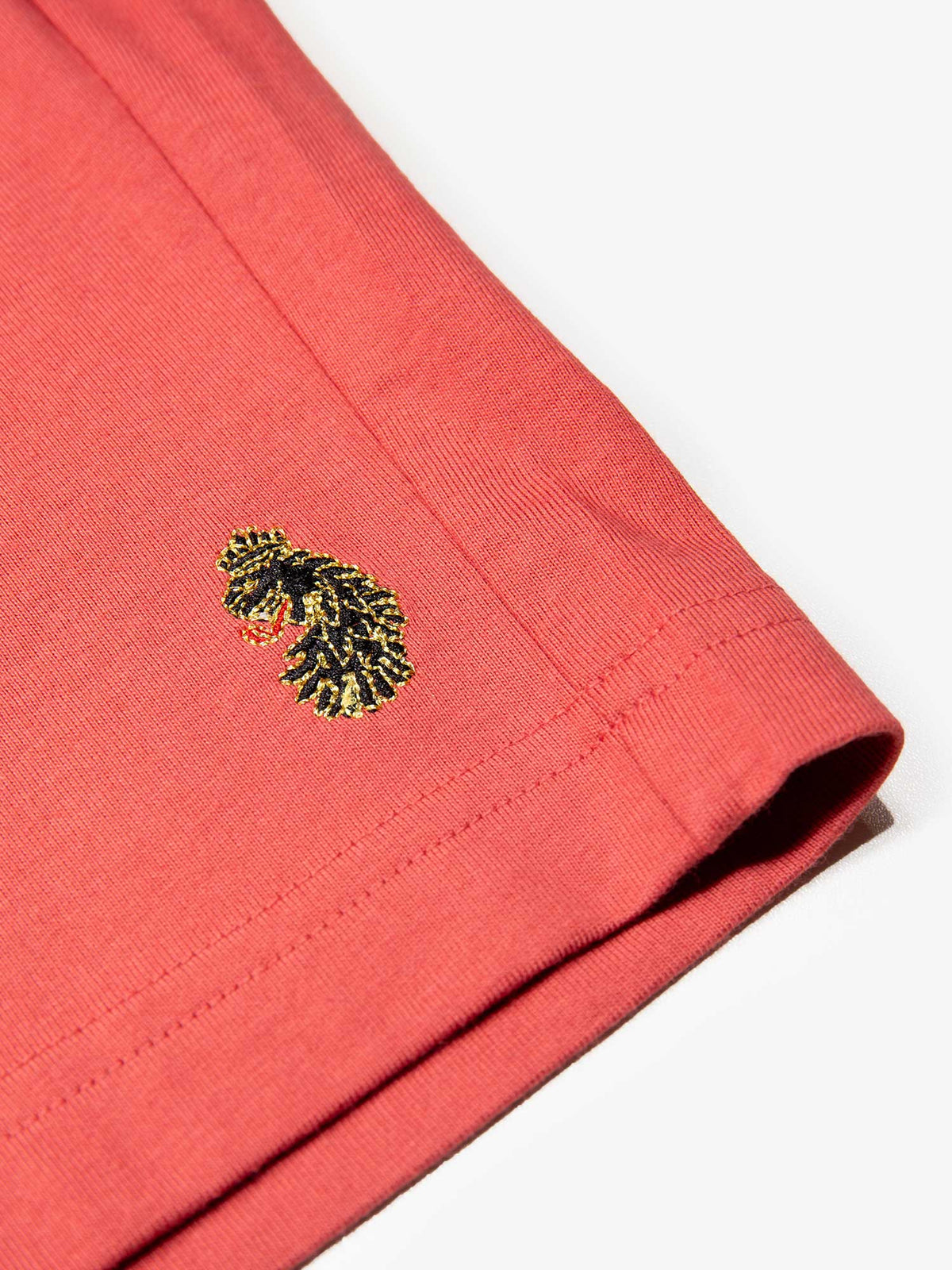 Men's red short set with short-sleeve shirt and drawstring shorts, detail view.