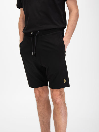 Men's black shorts with drawstring waistband, worn by a model, detail view