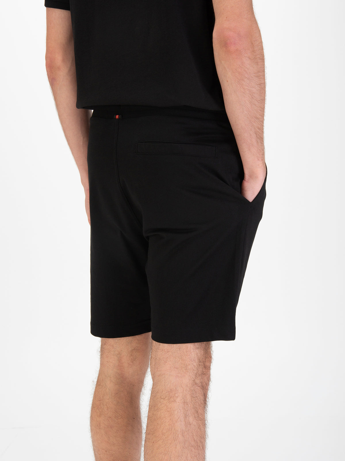 Men's black shorts with drawstring waistband, worn by a model, detail view