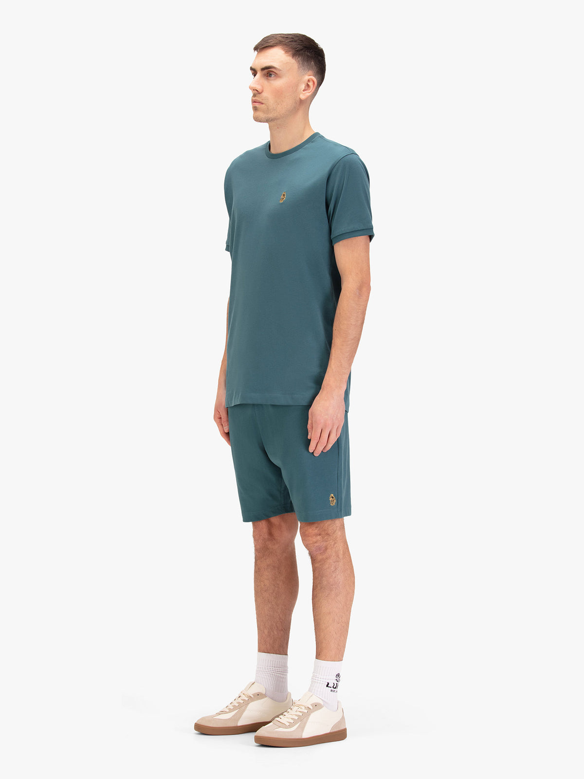 Men's blue short set with short-sleeve shirt and drawstring shorts, worn by a model, side view.