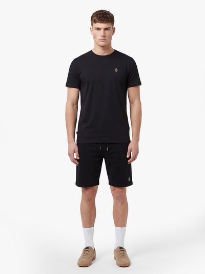Men's black short set with short-sleeve shirt and drawstring shorts, worn by model.