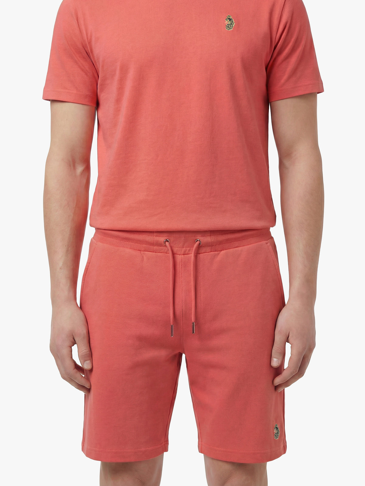 Men's red short set with short-sleeve shirt and drawstring shorts, worn by a model, front view.