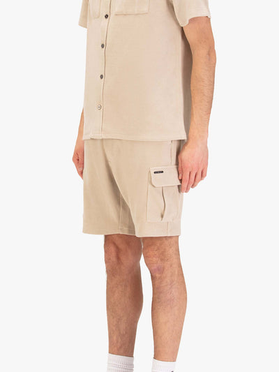 Men's beige shorts with drawstring waistband and cargo pockets, worn by a model, side view
