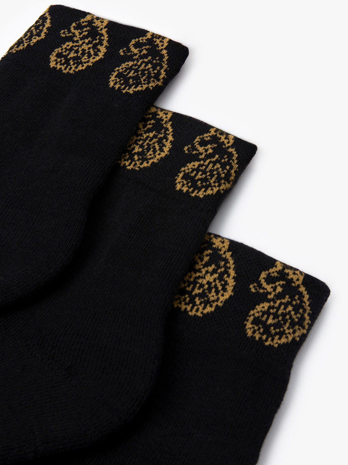 Close-up of gold LUKE lion head embroidery on black Zale ankle socks